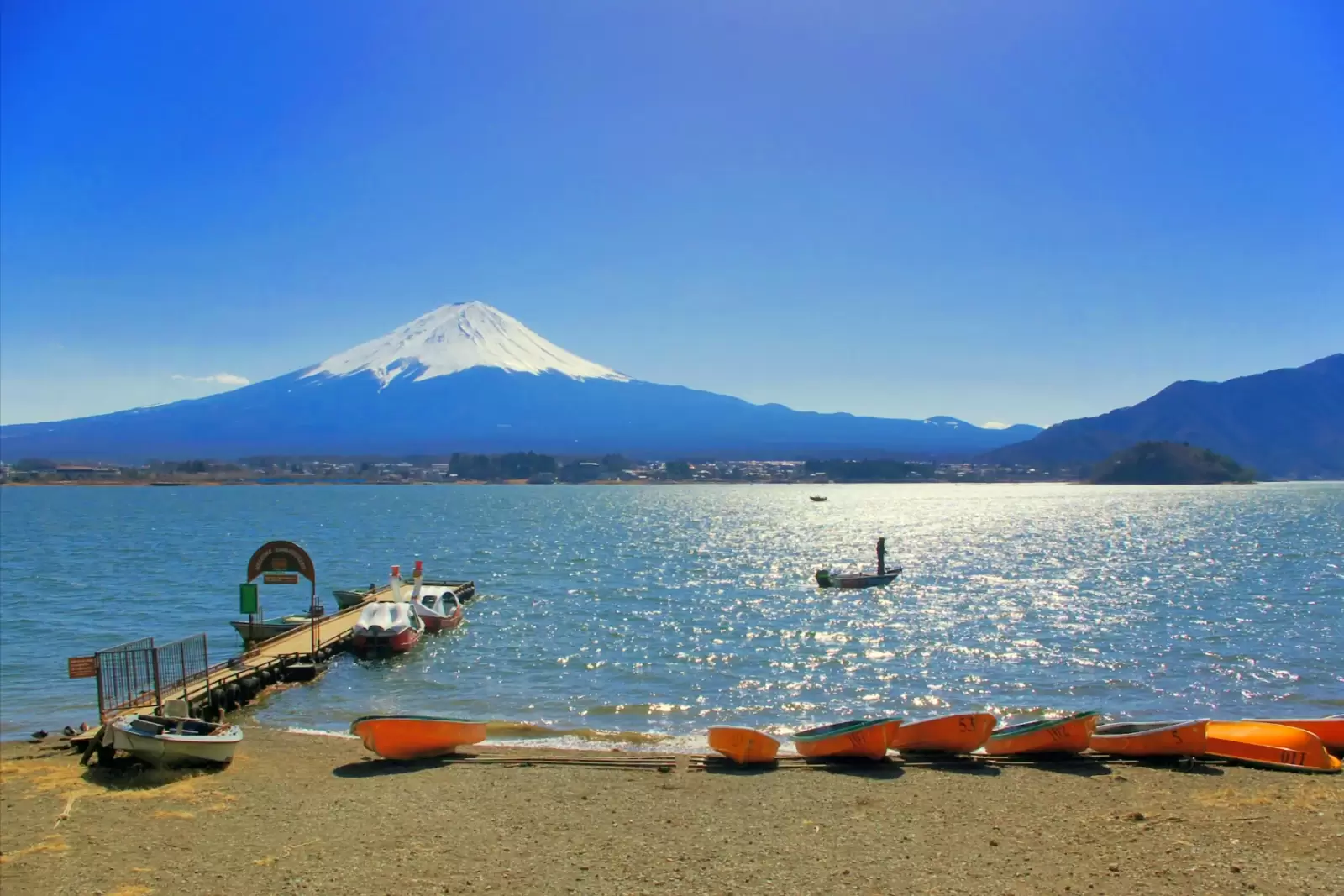 boats on kawaguchiko lake with fuji mountain background