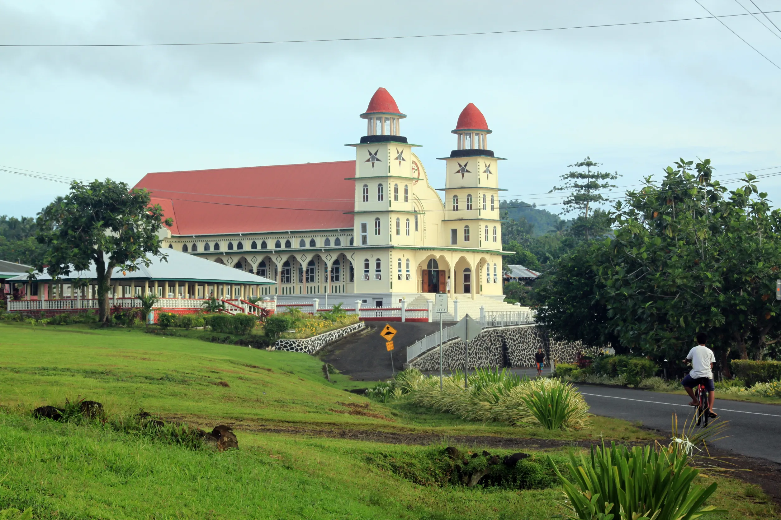 man on the bicycle and church in savaii island samoa