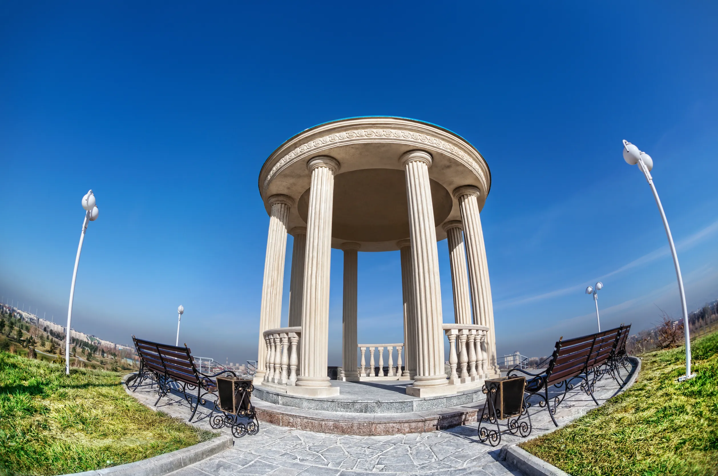 monument and benches at blue sky in dendra park of first president nursultan