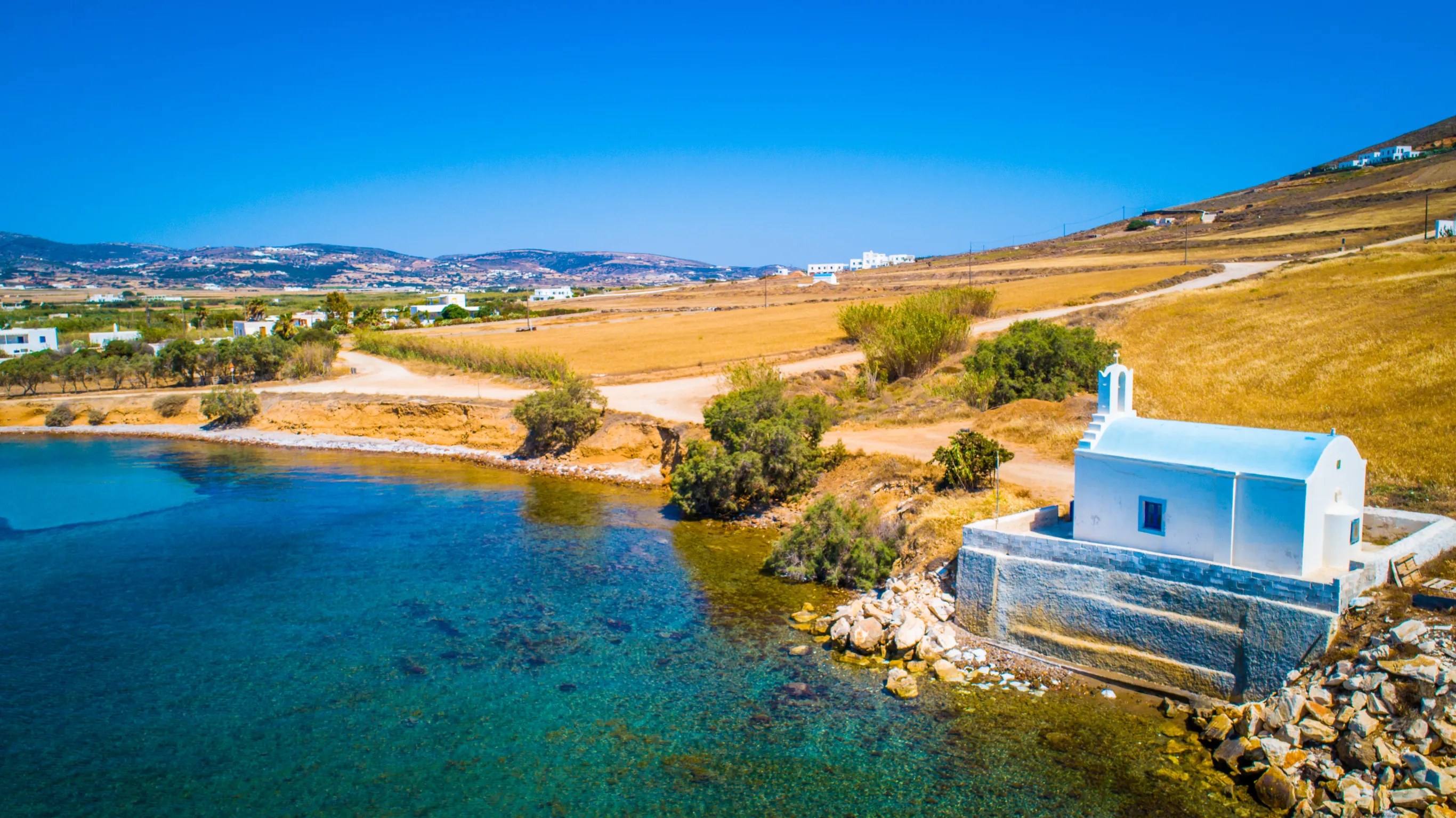 small greek church on a shore line of paros island greece