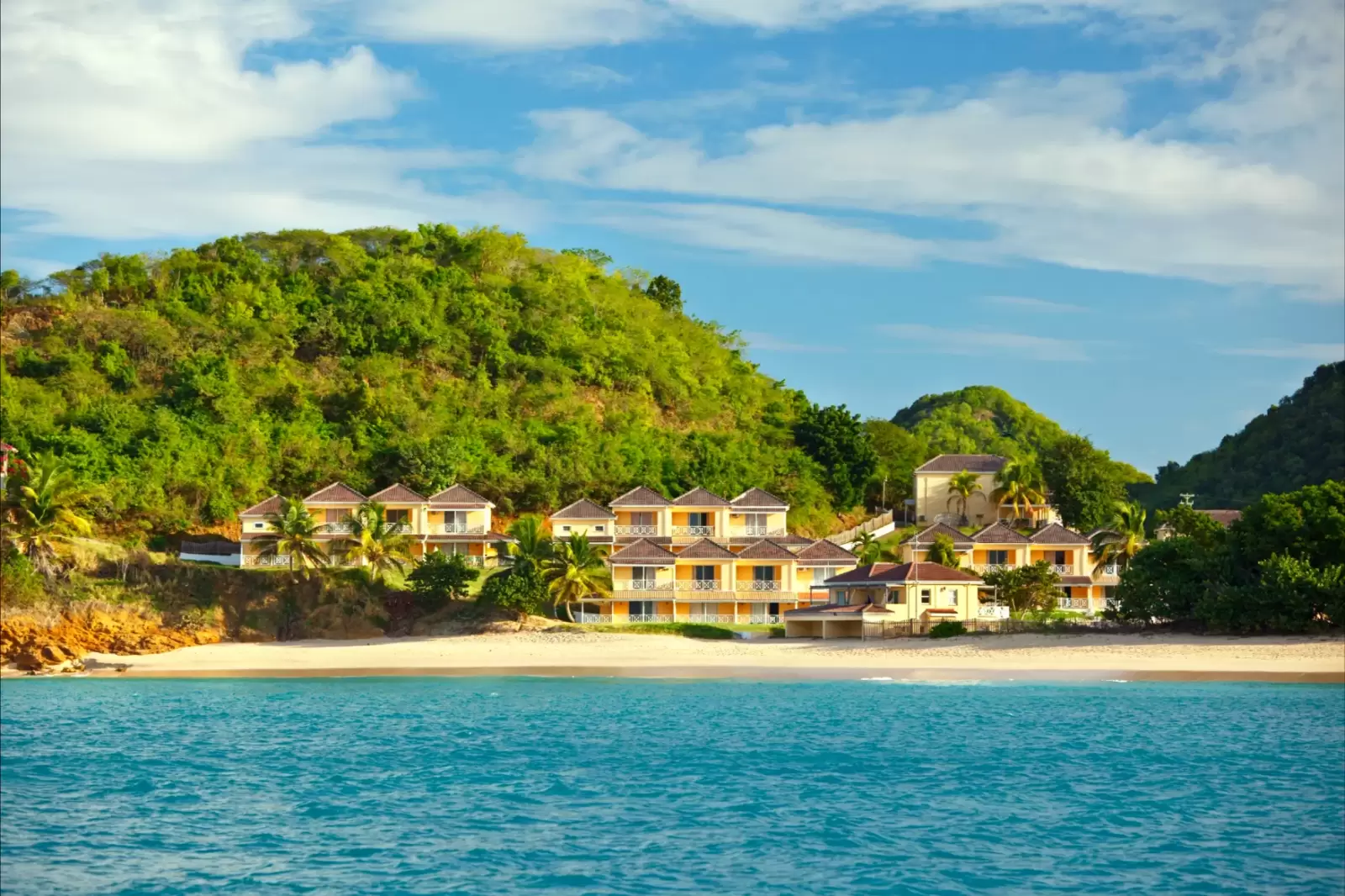 view to an antiguan beach and hotel from a boat